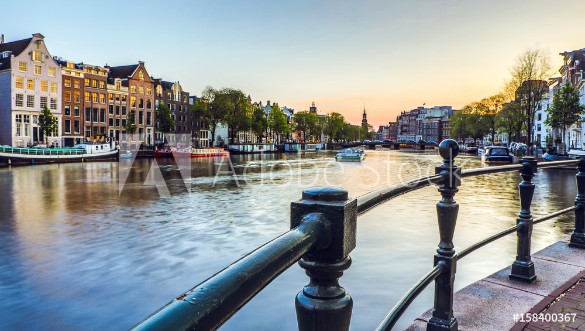 Picture of The most famous canals and embankments of Amsterdam city during sunset General view of the cityscape and traditional Netherlands architecture